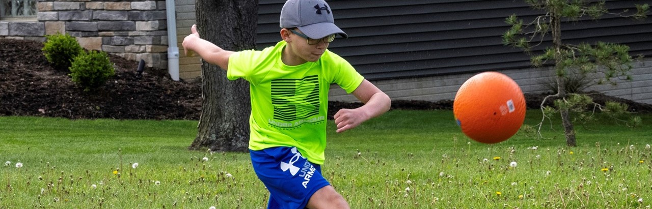 fourth-grade boy in green shirt with kickball