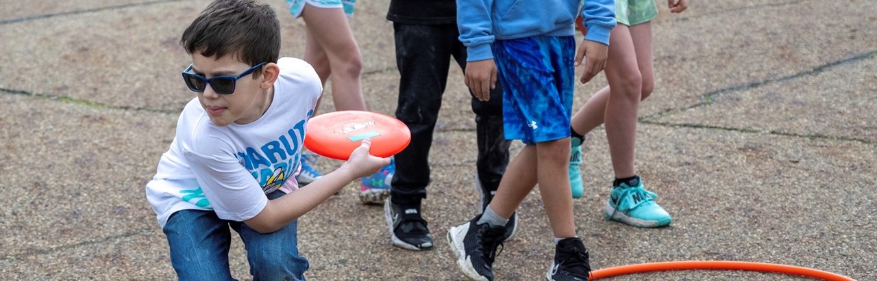 little boy throwing frisbee