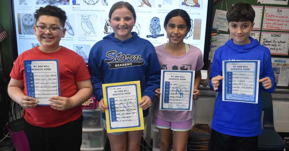 Students holding poems they wrote.