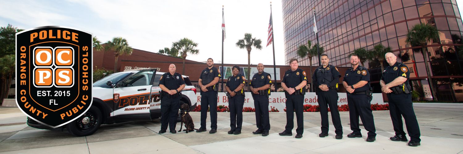 District Police and police dog in front of RBELC with white police car and simulated badge indicating established in 2015