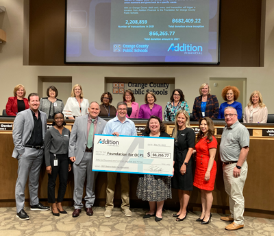 Group of people pose with a check donation