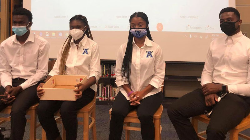 4 students stand next to each other to present