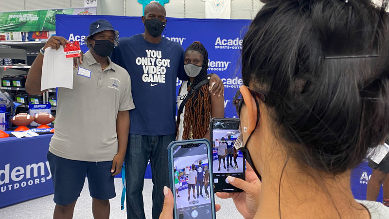 3 people pose with a gift card