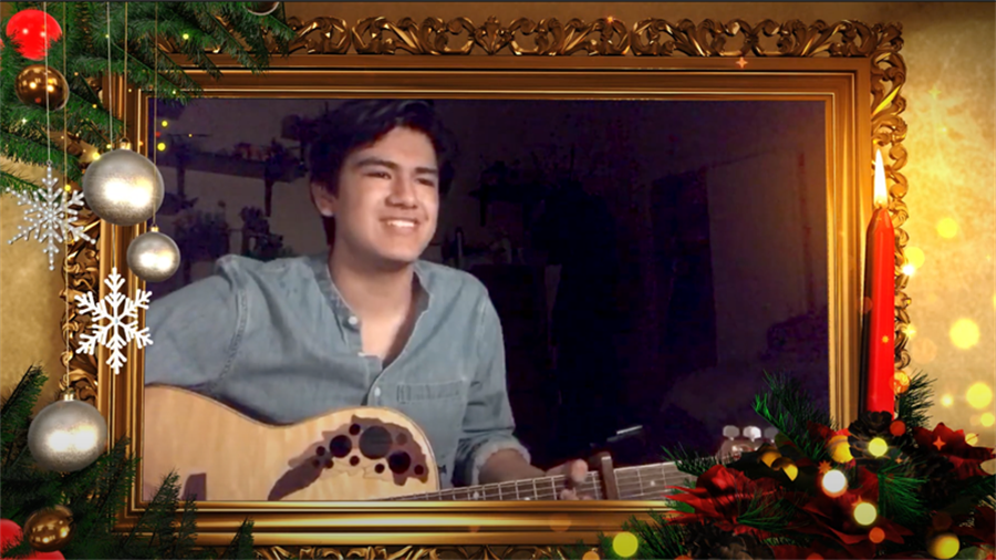 Boy playing guitar with holiday decor surrounding him