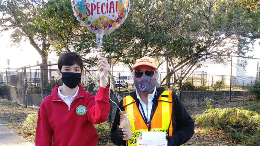 A male student and crossing guard stand next to each other