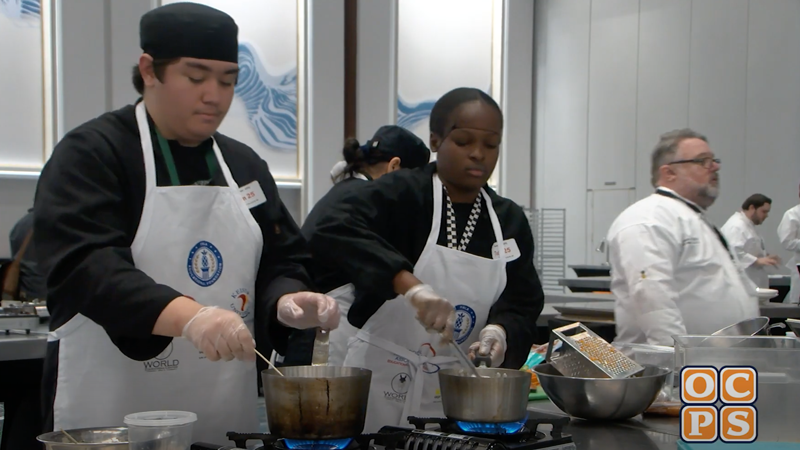 A male and female student cooking