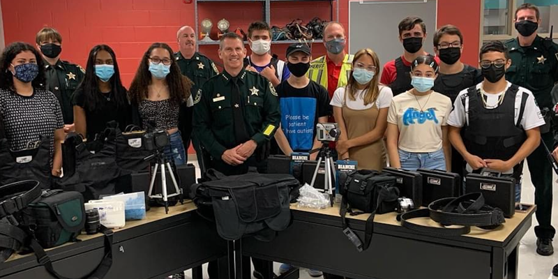 Sheriff Mina (center) poses with students and items donated