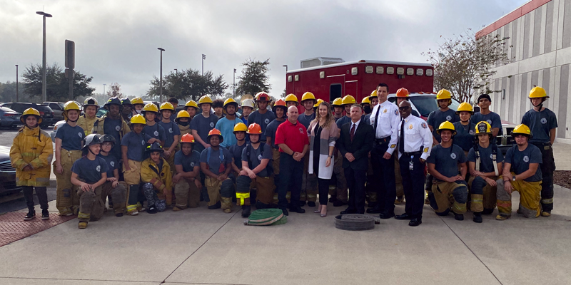 Group of people stand in front of donated fire rescue vehicle