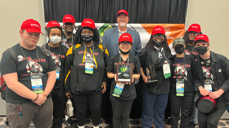 A group of people pose with an award plaque