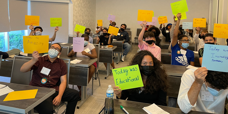 Students hold signs sharing thoughts of the day