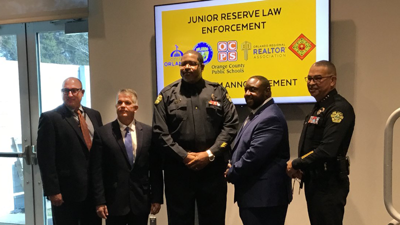 Five men stand side by side and smile for the camera