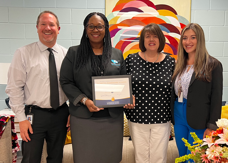 4 people smile with a certificate for Palmetto ES