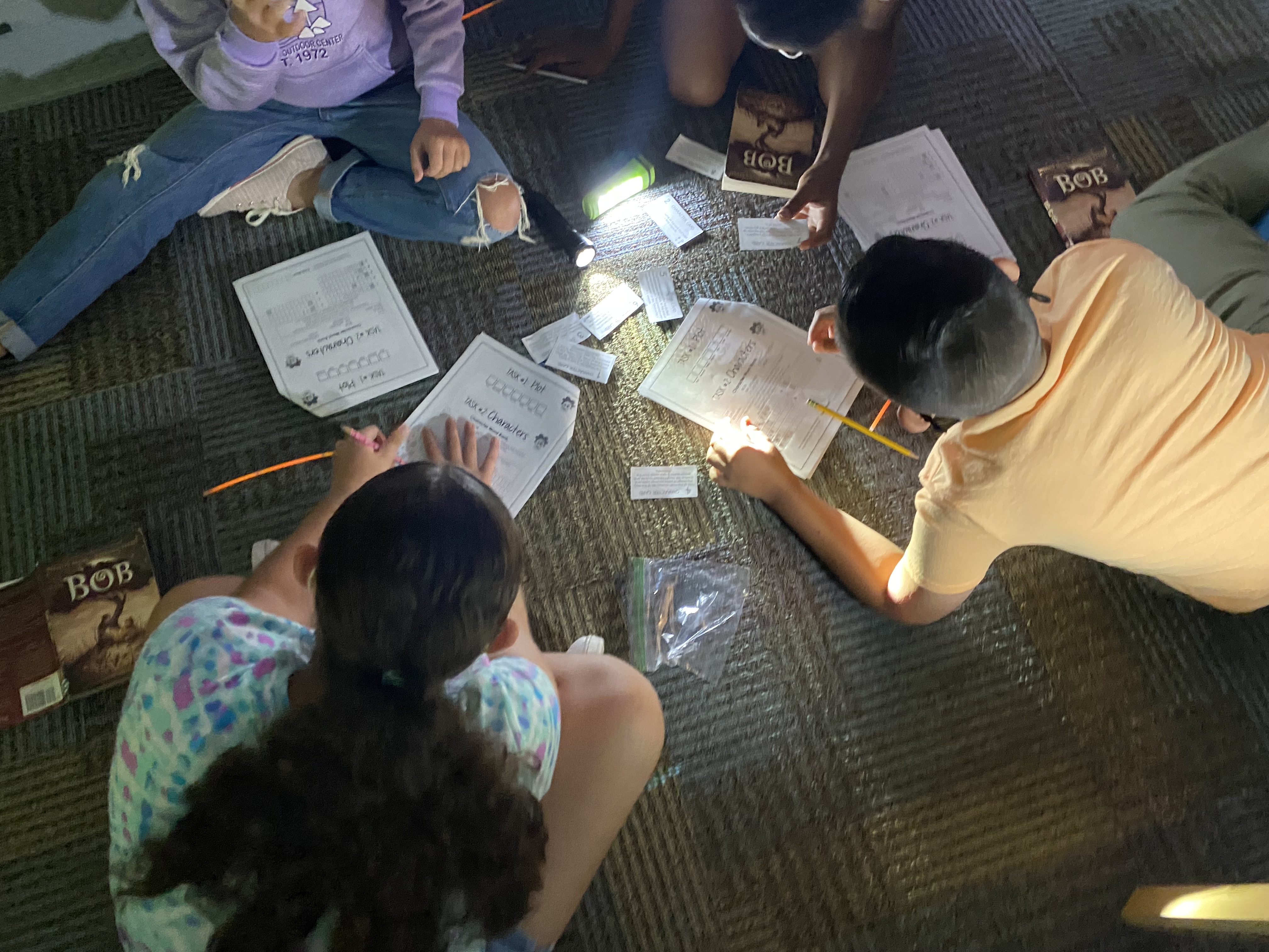 Students sit on floor working on Bob task