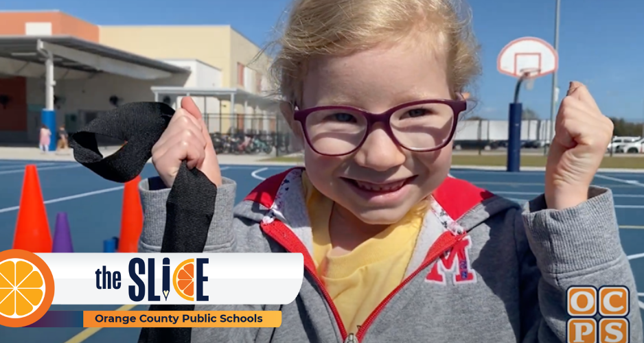 A little girl wearing glasses shows her muscles