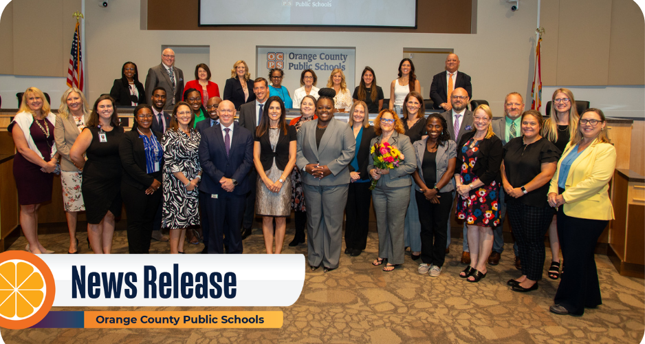 A large group of new administrators pose together in the board room