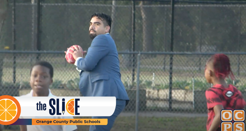 A man wearing a blue suit prepares to throw a football