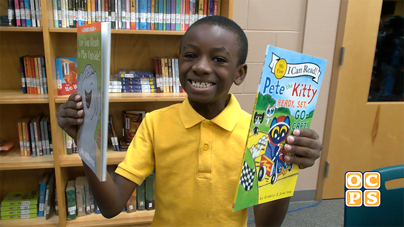 West Oaks student smiles while holding free books