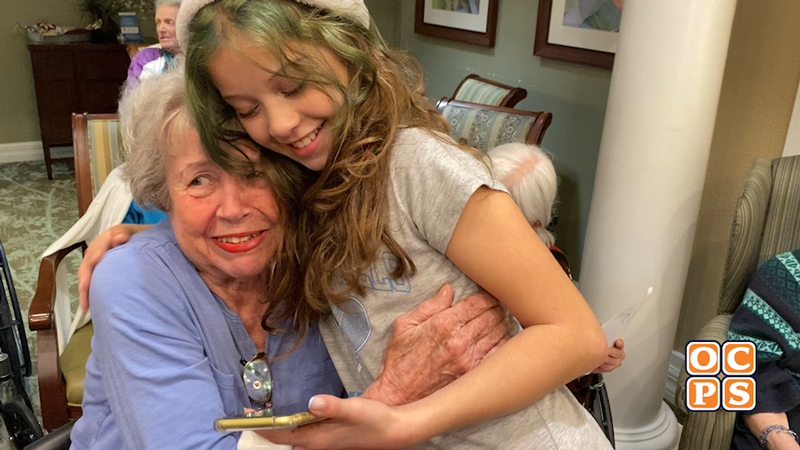 A female student hugs an elderly women