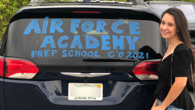 Agatha Sabino stands in front of her vehicle that says Air Force Academy bound