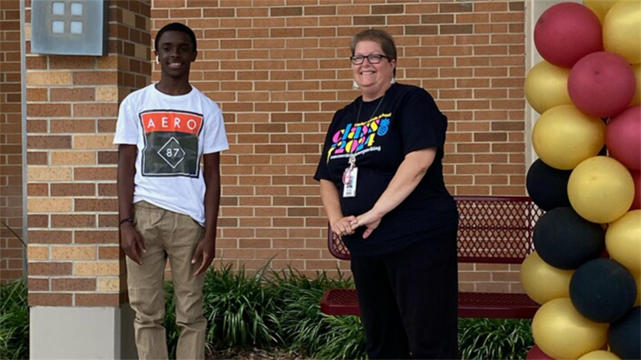 Principal Becky Watson poses with an 8th grade boy (socially-distanced)