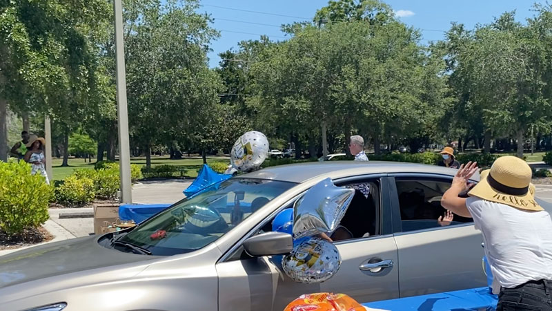 Teacher waving to student in car