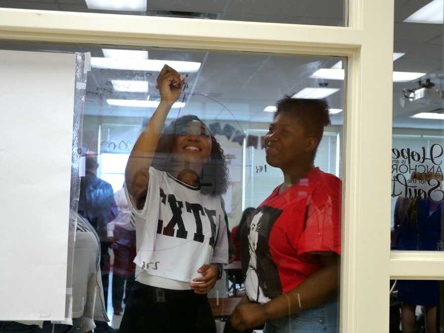 Two students work a math problem on a window