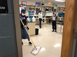 3 custodians clean a classroom