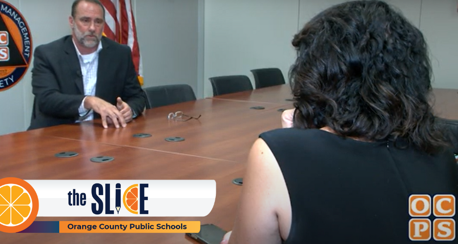 Man and reporter speak in board room