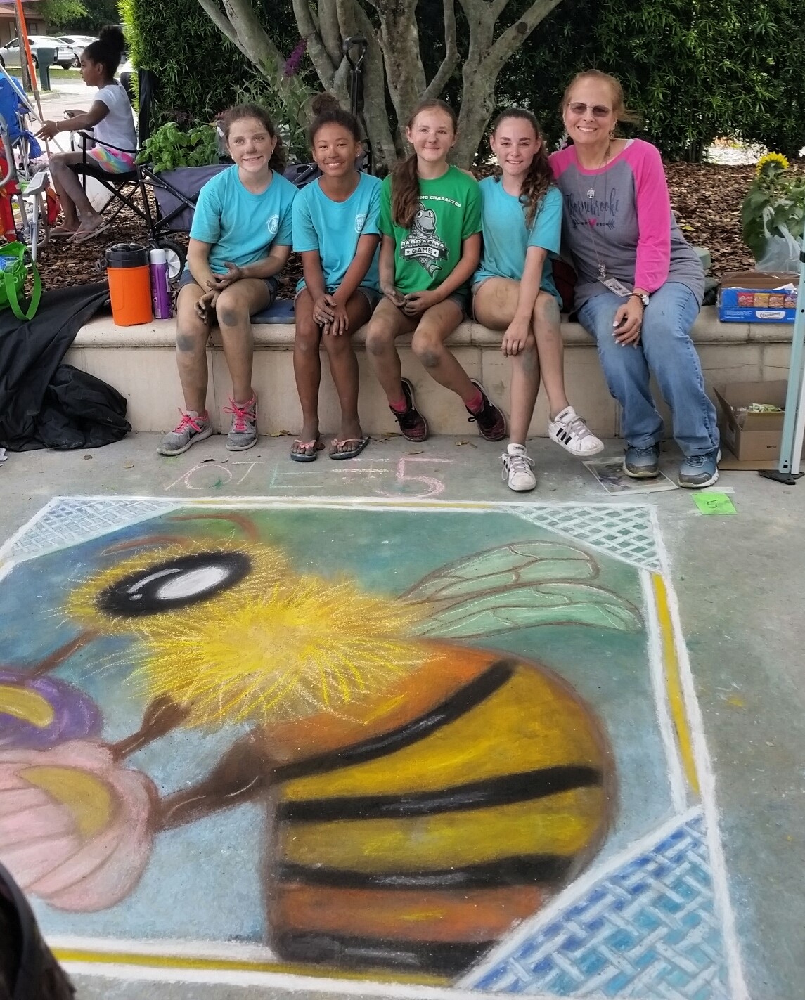 Chalk art team with Mrs. Eastham in front of chalk art bee