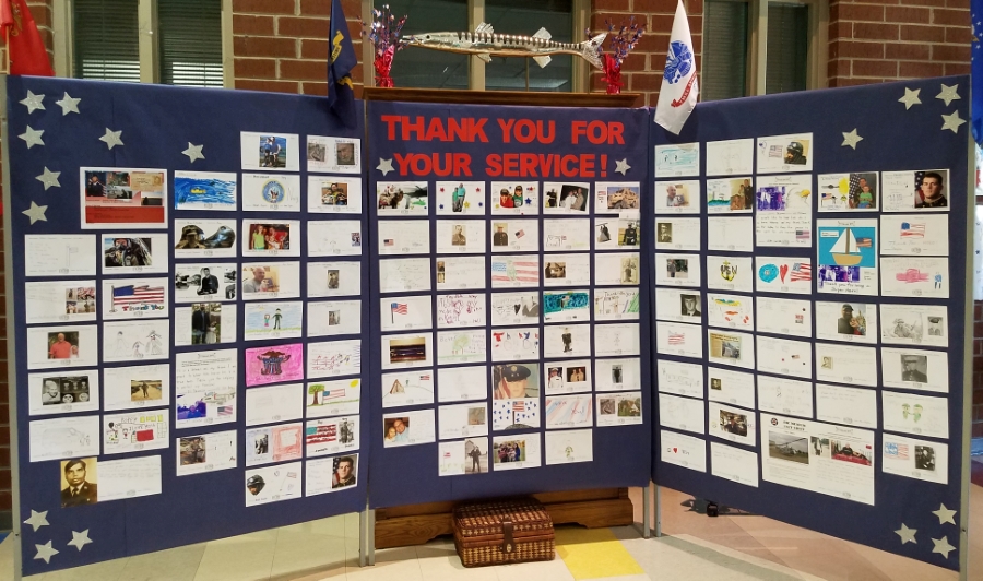 Honor wall with cards honoring veterans made by students
