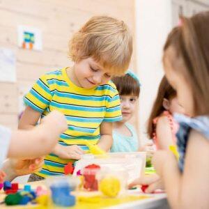 Young Male Student Playing With Toys And Smiling