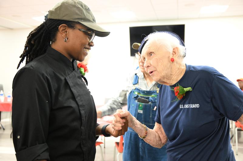 the youngest veteran at the event, DeShundra Beasley, and the oldest, a 101-year-old Coast Guardsman talk, smile and hold hands