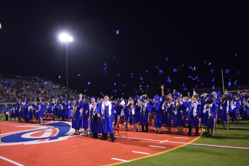 graduates throwing their caps
