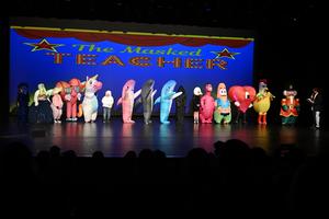 16 teachers dressed in disguises on stage