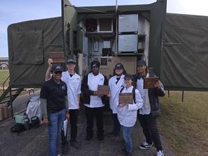 Culinary students pose with their awards with their instructor