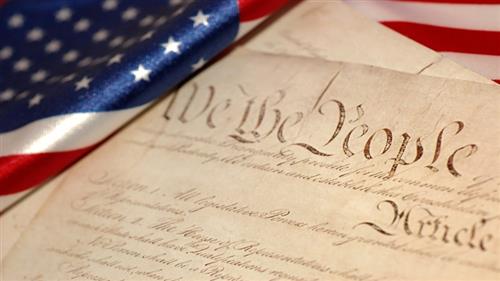 Picture of the Constitution next to an American Flag 