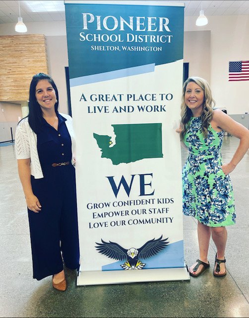 Two women next to Pioneer School District sign