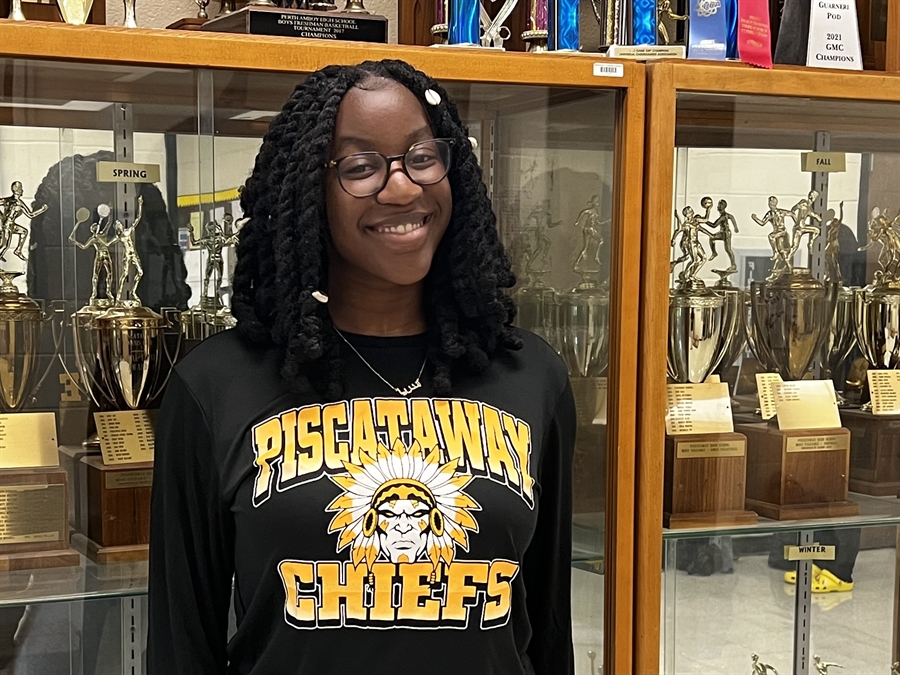 student in front of trophy case