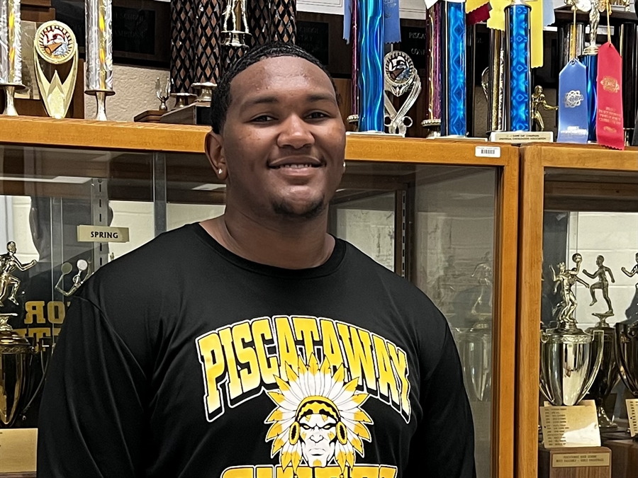 student in front of trophy case