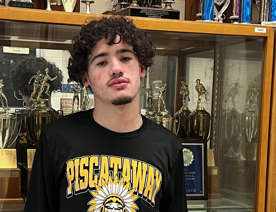 student in front of trophy case