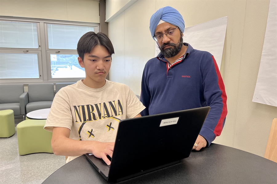 student and teacher at laptop