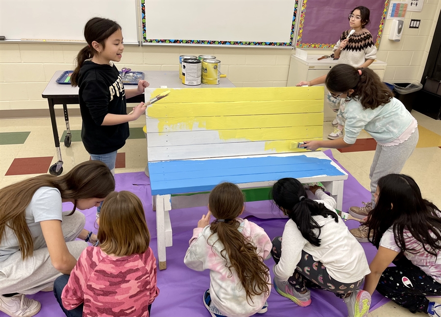 students painting bench