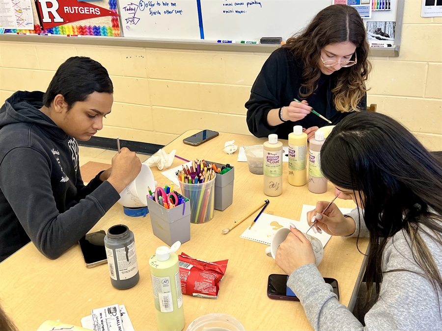 students painting mugs