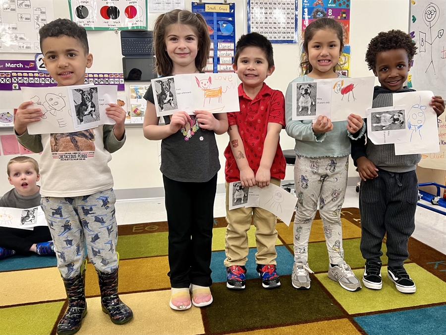 preschoolers holding drawings