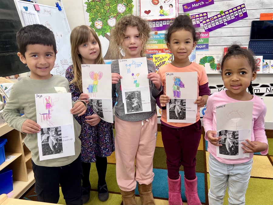 preschoolers holding drawings