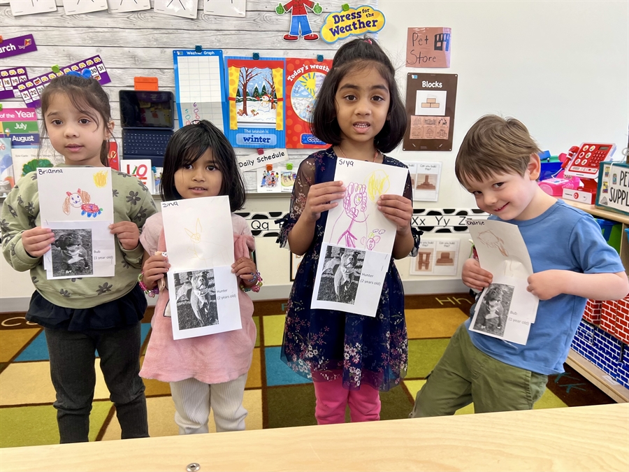 preschoolers holding drawings