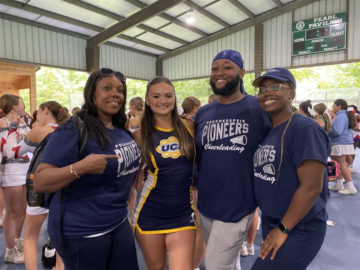 Poughkeepsie coaches pose with a UCA cheerleader