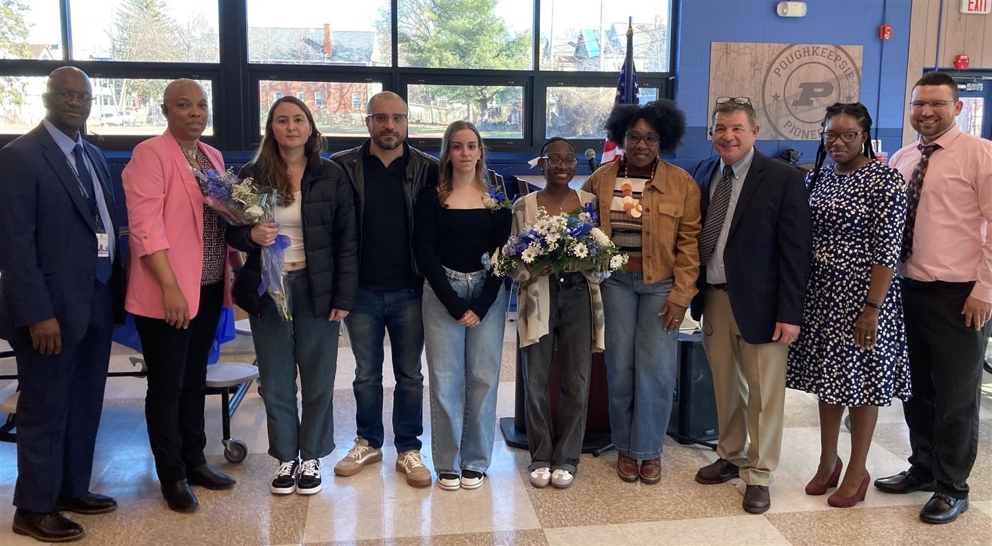  10 people stand in a line, including salutatorian Salome Vergara and valedictorian Jhanae Stewart