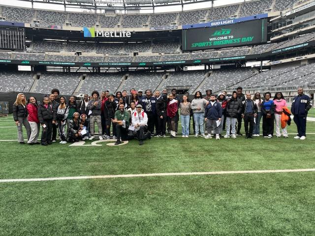  Around 50 students and educators pose together on the MetLife Stadium field.