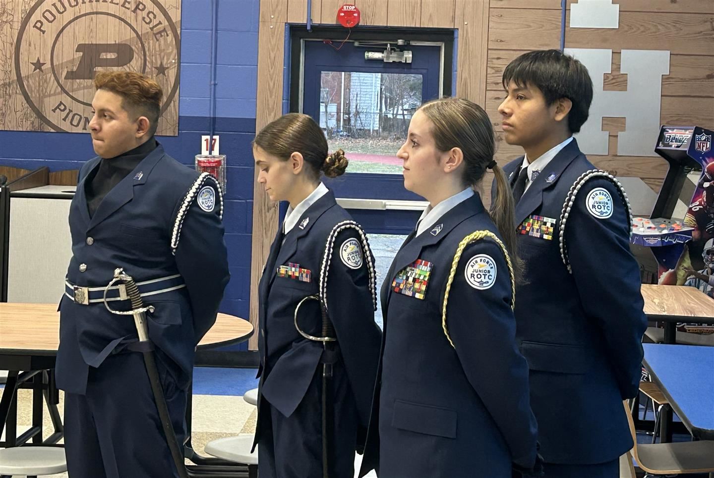Four cadets stand and listen